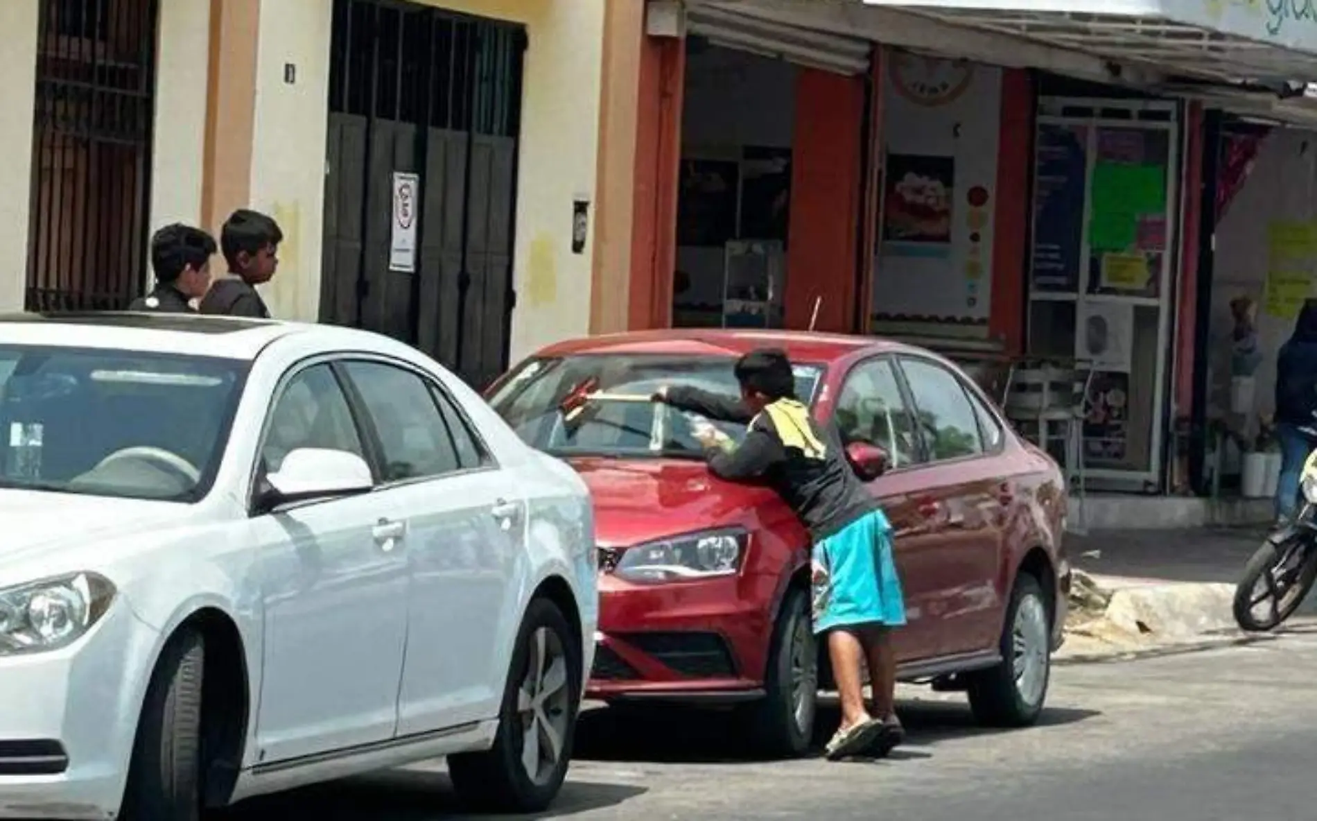 niño limpiando parabrisa